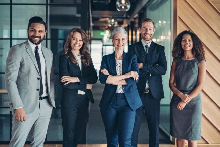 Confidence and success Multi-ethnic group of business persons standing side by side